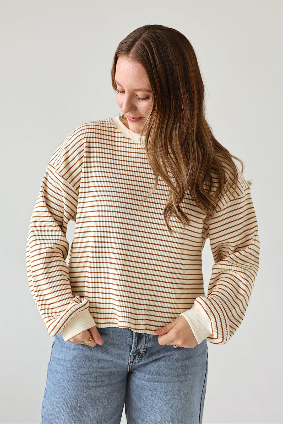 Model styling the Alessia cream and brown striped top with denim