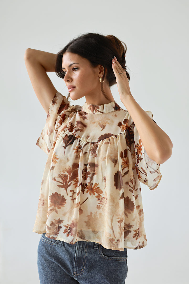 Model wearing the Florence floral mockneck blouse with warm brown botanical print