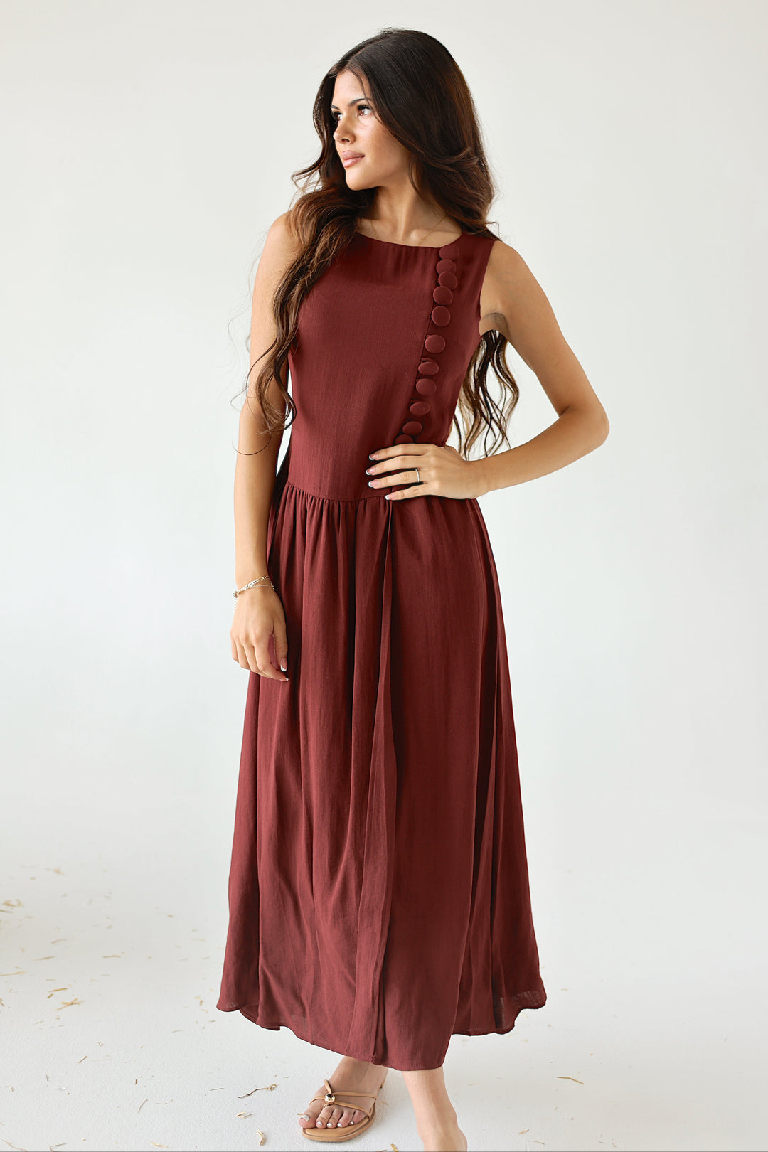 Model wearing the Margot burgundy drop waist midi dress with covered button detailing