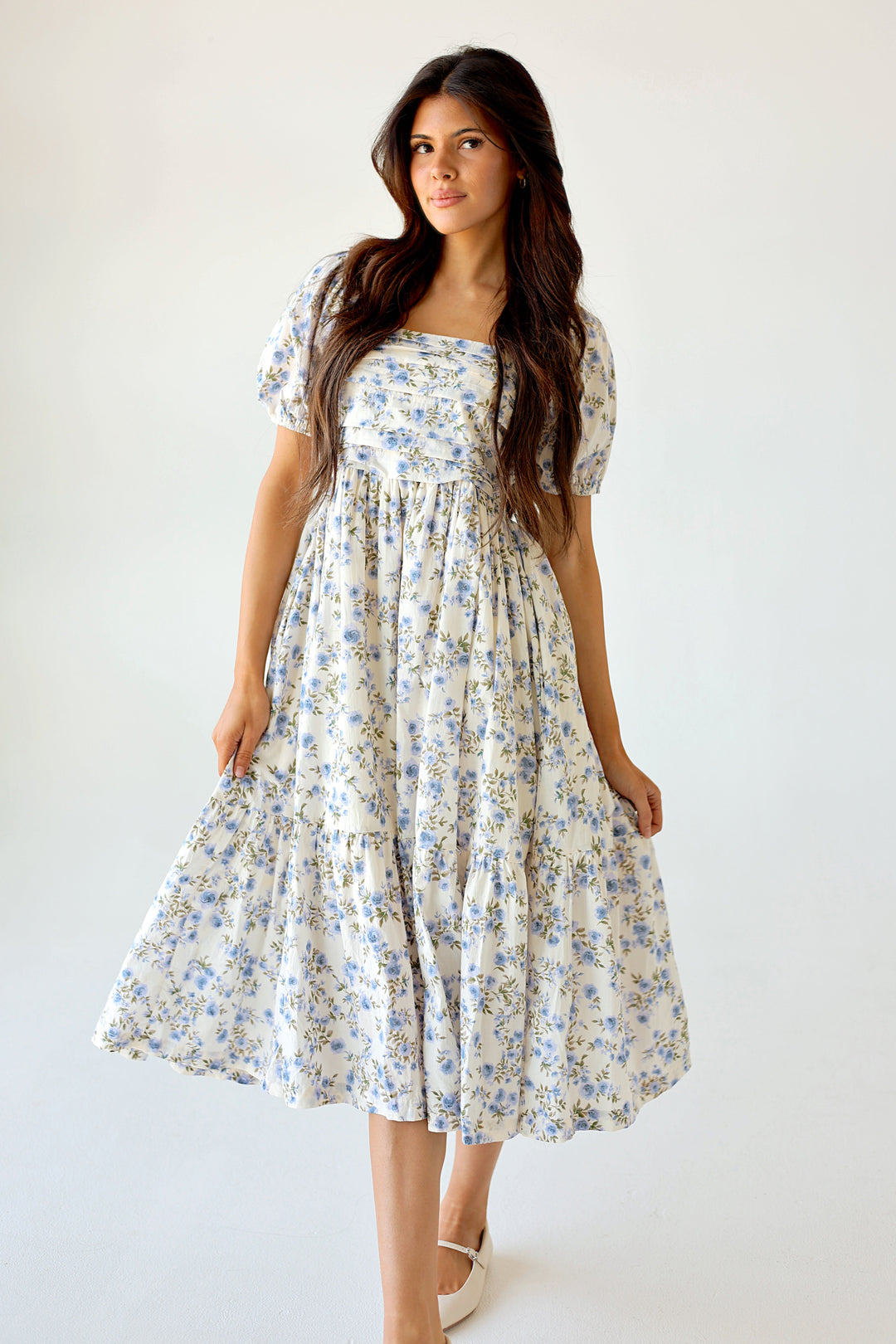 Woman wearing a floral dress against a white background