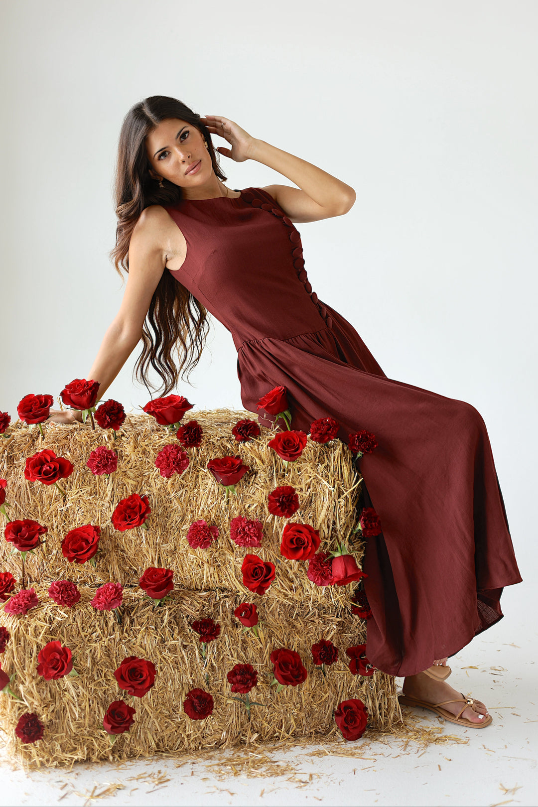 Model styling the Margot sleeveless burgundy midi dress with a drop waist