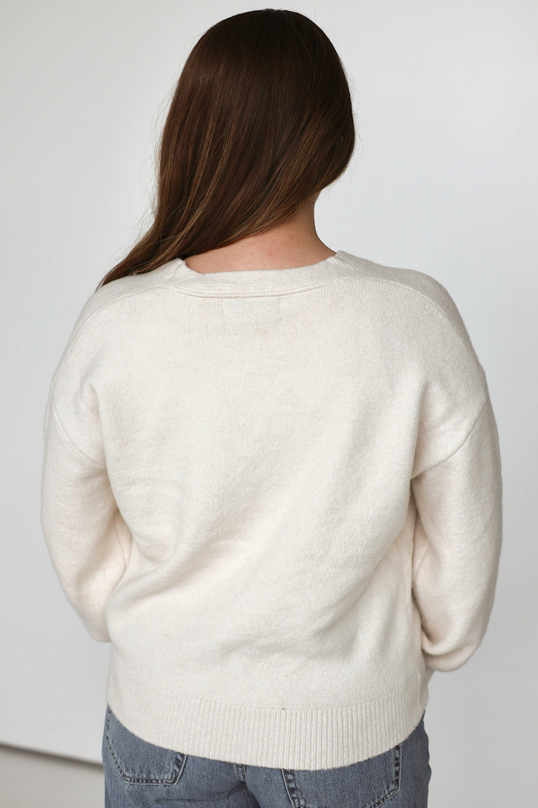 Model wearing the Rosalie floral embroidered cardigan in ivory with rust floral details