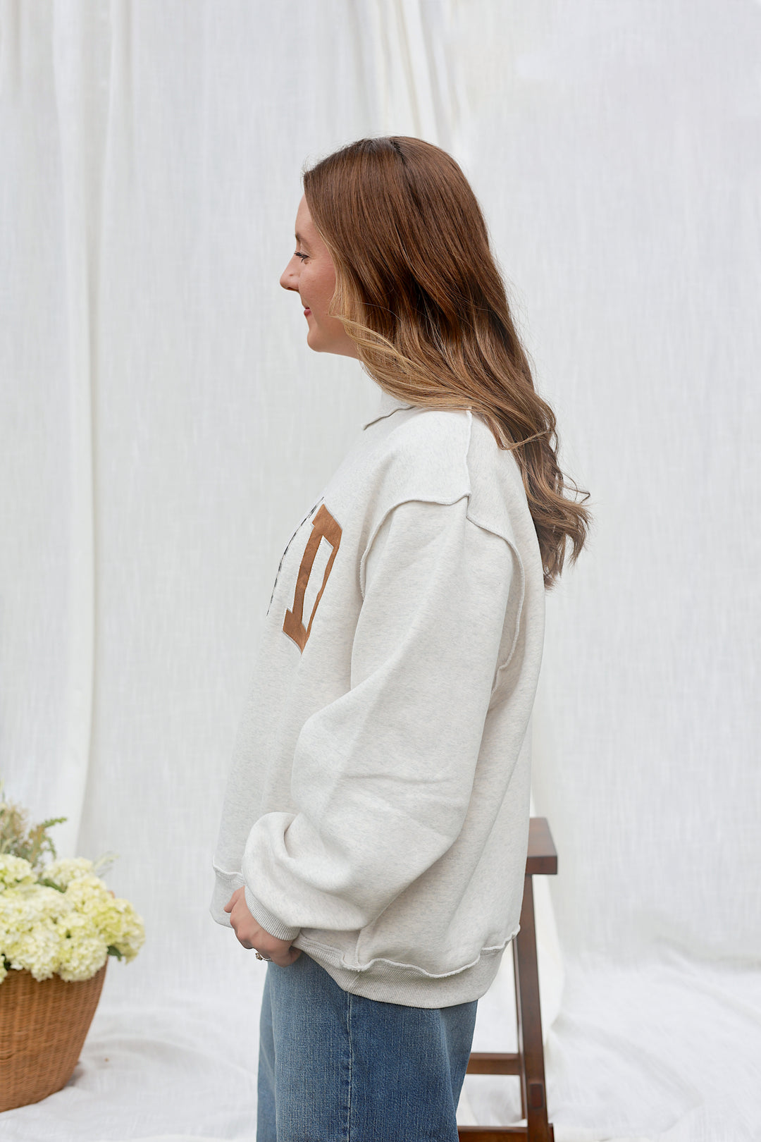 Side view of model wearing the oversized ash grey WWJD mockneck sweatshirt.