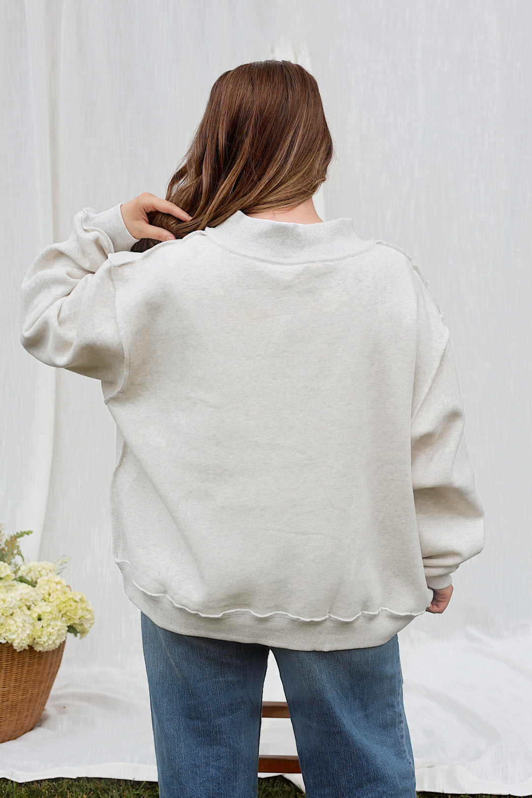Back view of model wearing the oversized ash grey WWJD mockneck sweatshirt.
