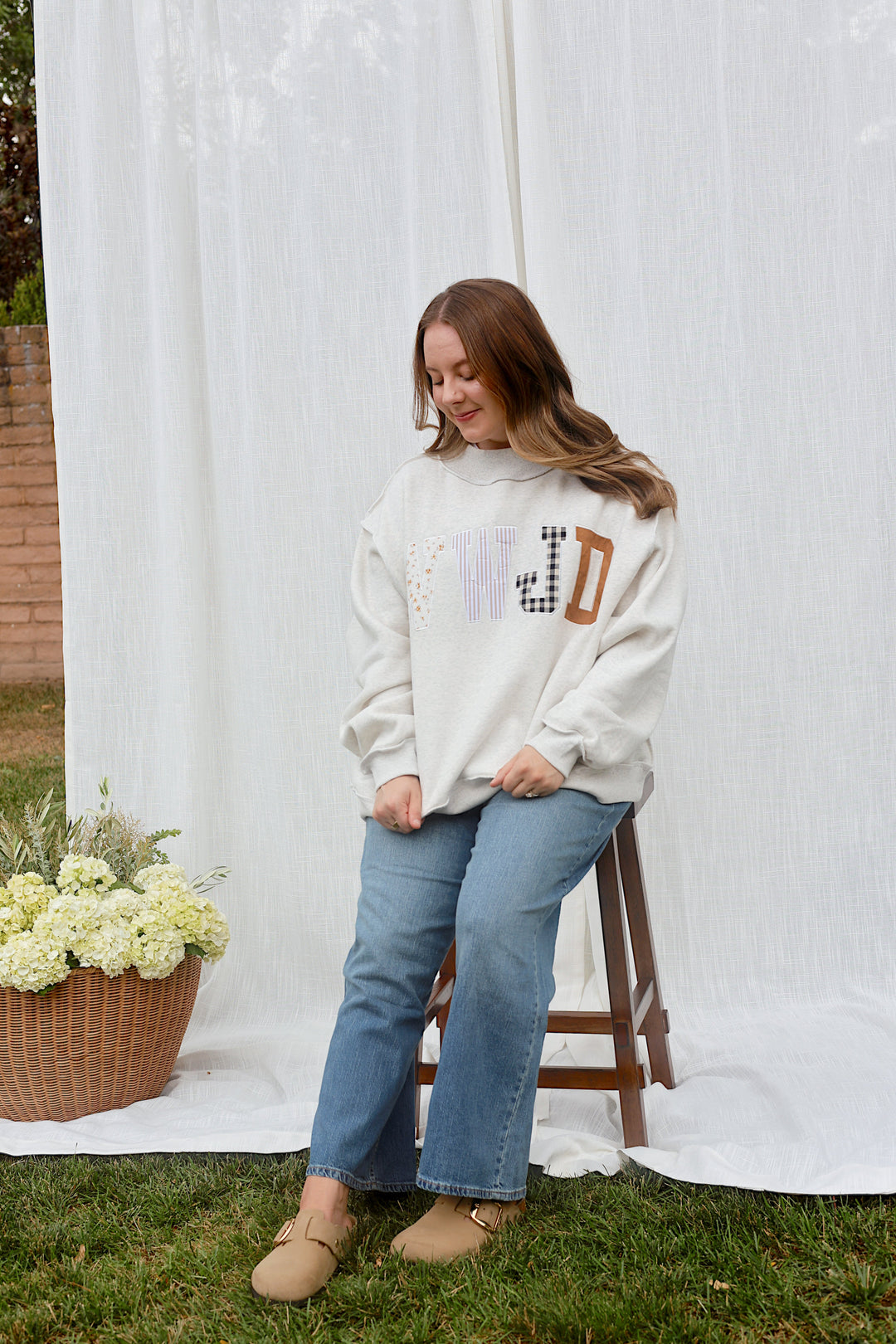 Back view of model wearing the oversized ash grey WWJD mockneck sweatshirt.