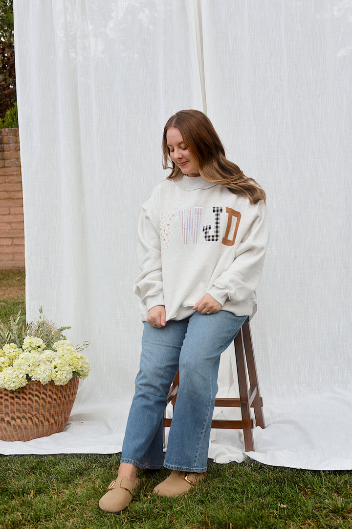 Back view of model wearing the oversized ash grey WWJD mockneck sweatshirt.
