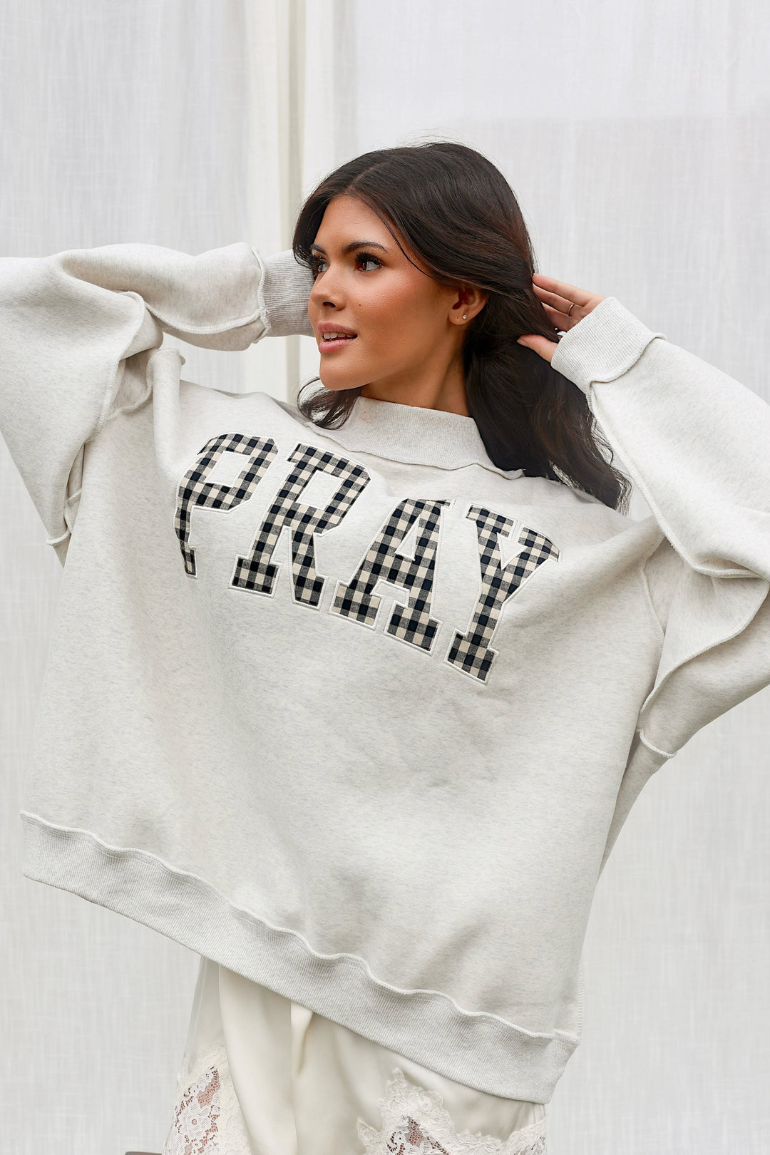 Full-length front view of model wearing the oversized PRAY gingham mockneck sweatshirt.