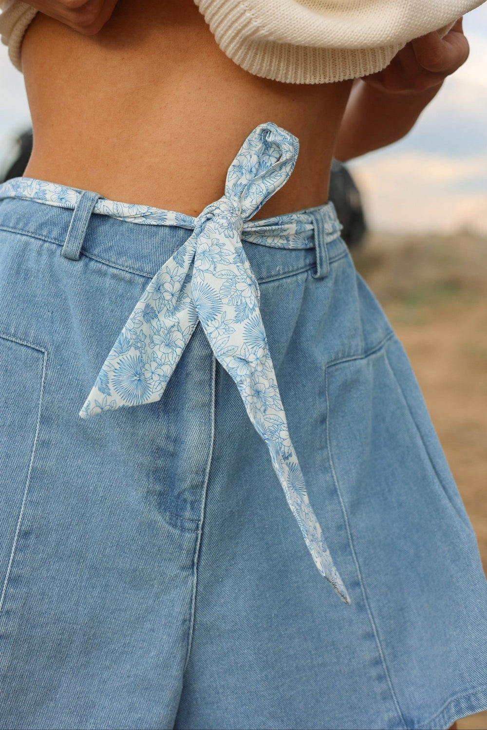 Savannah High - Rise Flounce Denim Shorts with Floral Sash - Bacio & Co.
